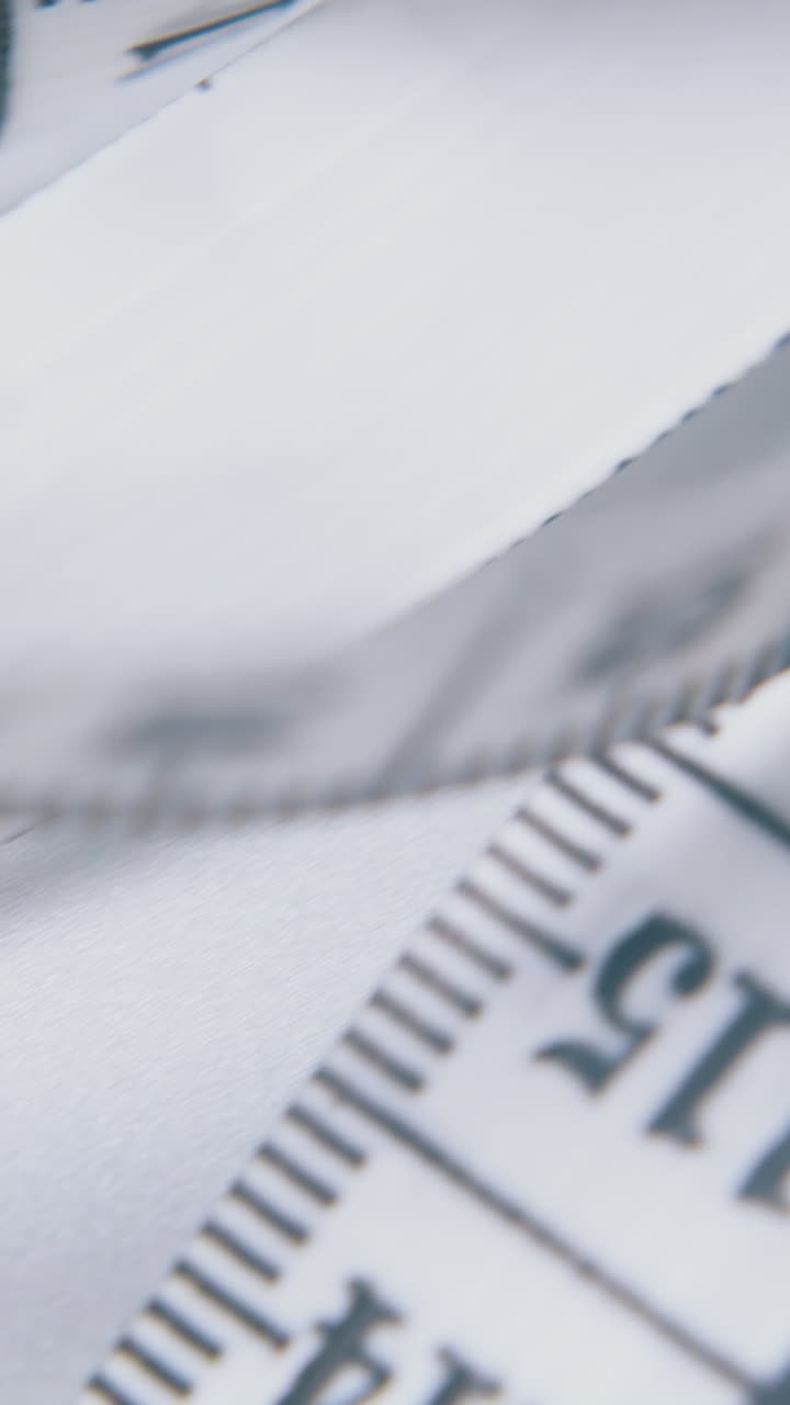 long white soft plastic measuring tape with calibrated in centimeters lies on light grey surface extreme close view