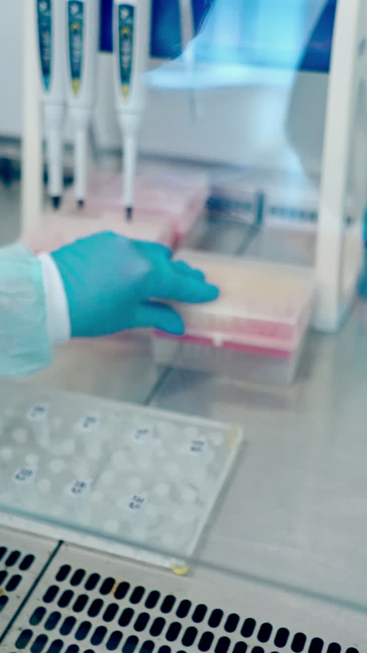 Medical equipment blood test in laboratory. Female technician analyzing blood sample in medical laboratory. Vertical video