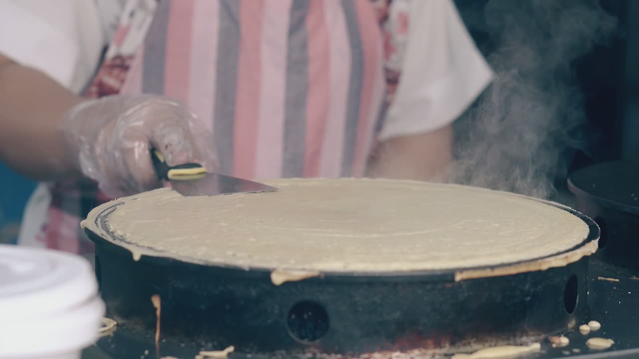mujer prepara panqueques en la máquina de crepes en una cafetería de comida rápida