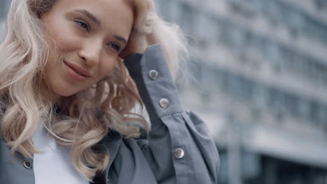 model posing city landscape with blonde hair in urban building background.