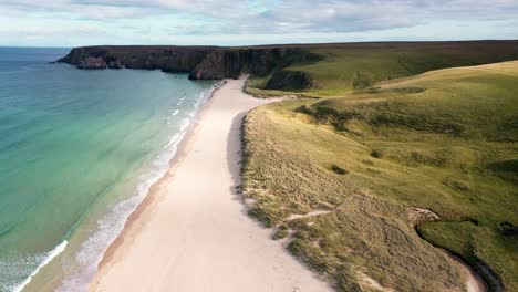 drone shot featuring couples walking of traigh mhor in tolsta village on the outer hebrides of scotland