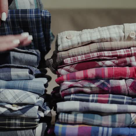 Women's-hands-sort-through-a-stack-of-men's-shirts-2
