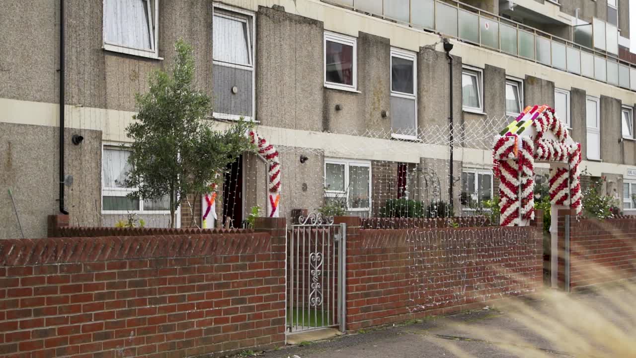 입구 에 활기찬 꽃 장식 과 우아 한 요정 불빛 이 있는 결혼식 집 의 전망