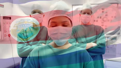 Animation-of-waving-costa-rica-over-portrait-of-team-of-diverse-surgeons-at-hospital