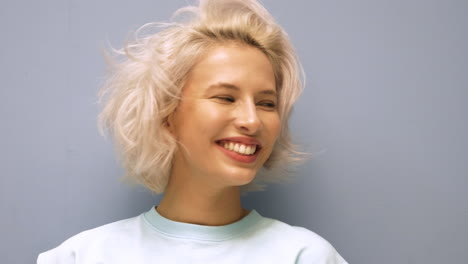 mujer sonriente con cabello rubio corto