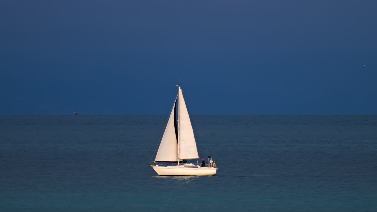 Distant view of a sailing boat moving on the sea