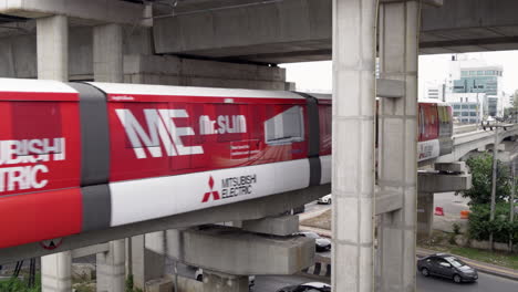 an electric train of the pink line arrives at the station platform, providing reliable urban transit in bangkok.