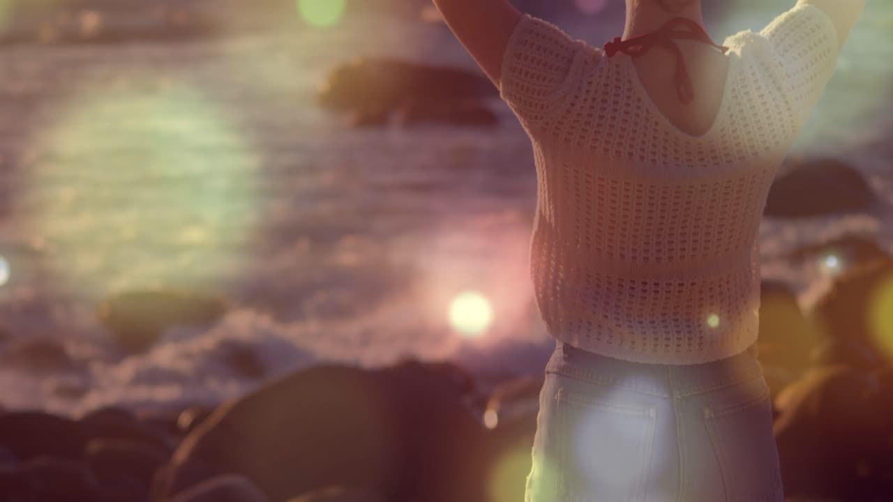 Animazione di punti luce su una donna caucasica in spiaggia.