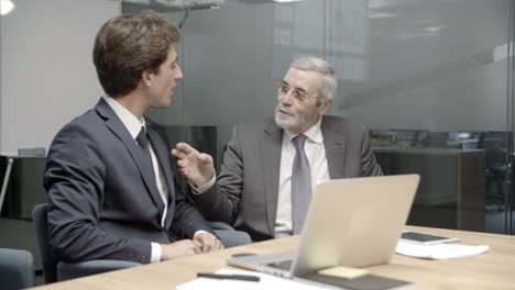 two office employees sitting at table and working over project