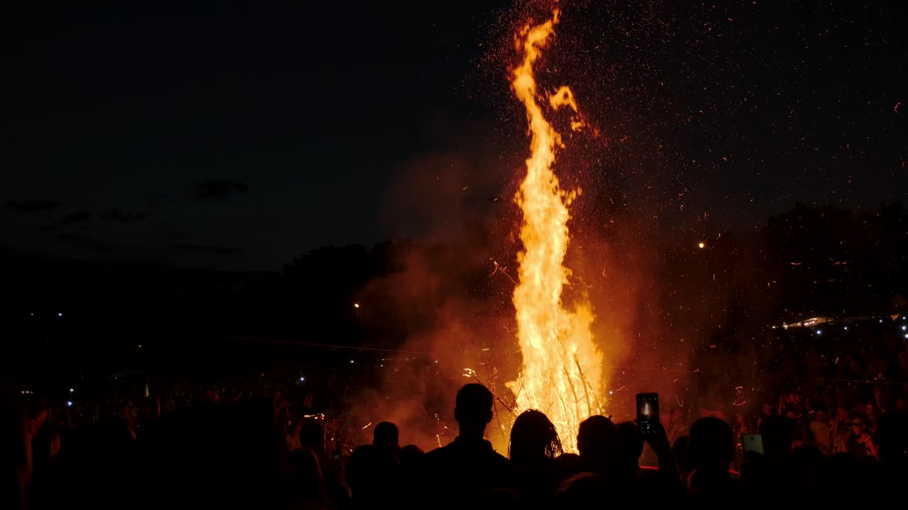 축제 에서 큰 불 을 둘러싸고 서 있는 사람 들