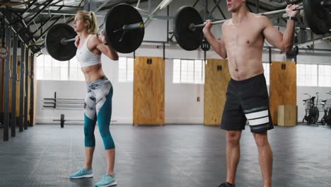 Side-view-of-an-athletic-Caucasian-man-and-woman-squatting-