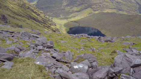 tilt up shot of a wonderful lake from the top of a high mountain on a wonderful day in ireland in 4k