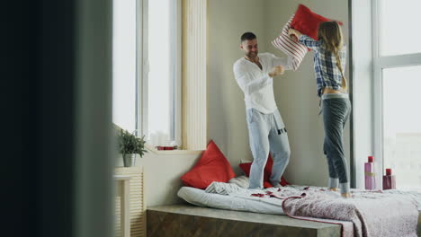 couple having a fun pillow fight at home during christmas