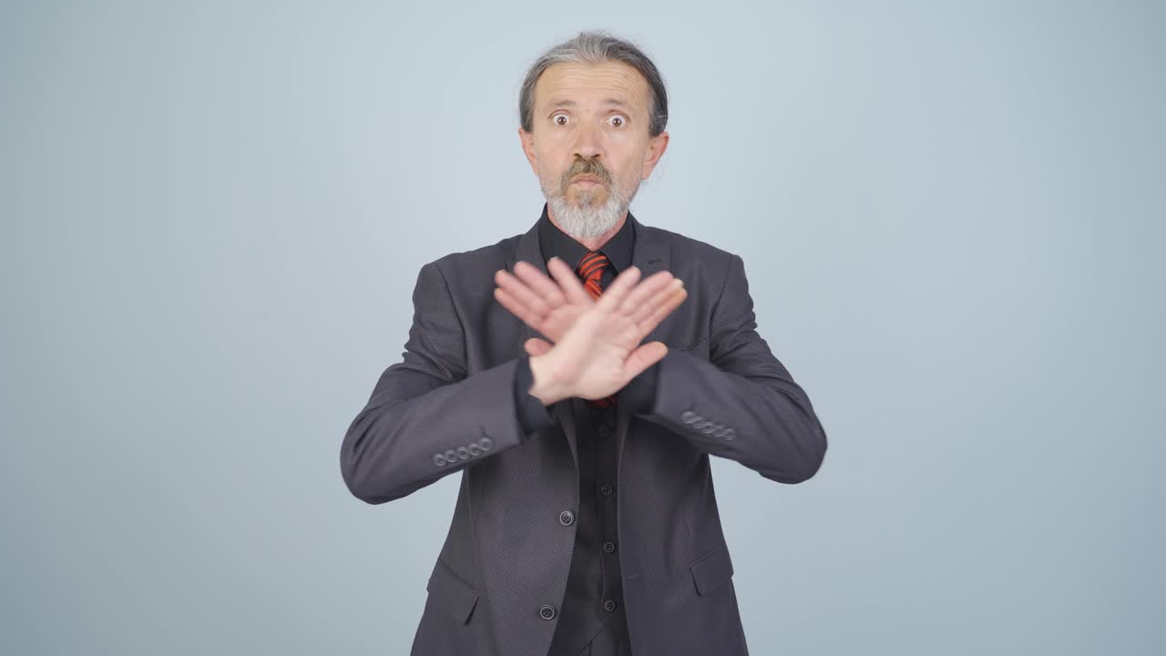 비즈니스맨이 엄격한 표정으로 카메라를 경고하고 있습니다.