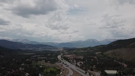 aerial shot, slowing flying backwards along a mountain highway near ski resort in keystone colorado.