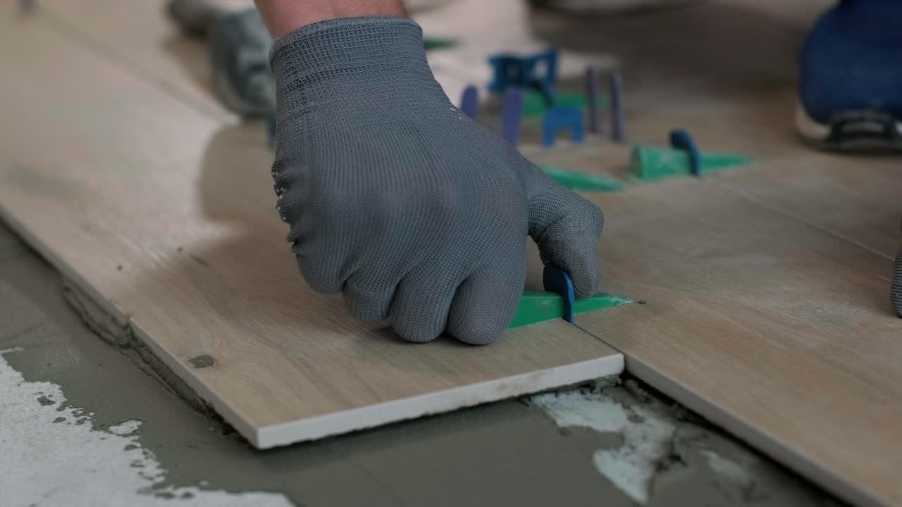 Installing ceramic floor tiles - measuring and cutting the pieces. Construction, renovation, repair apartment. Cuts tile. Tile cutting