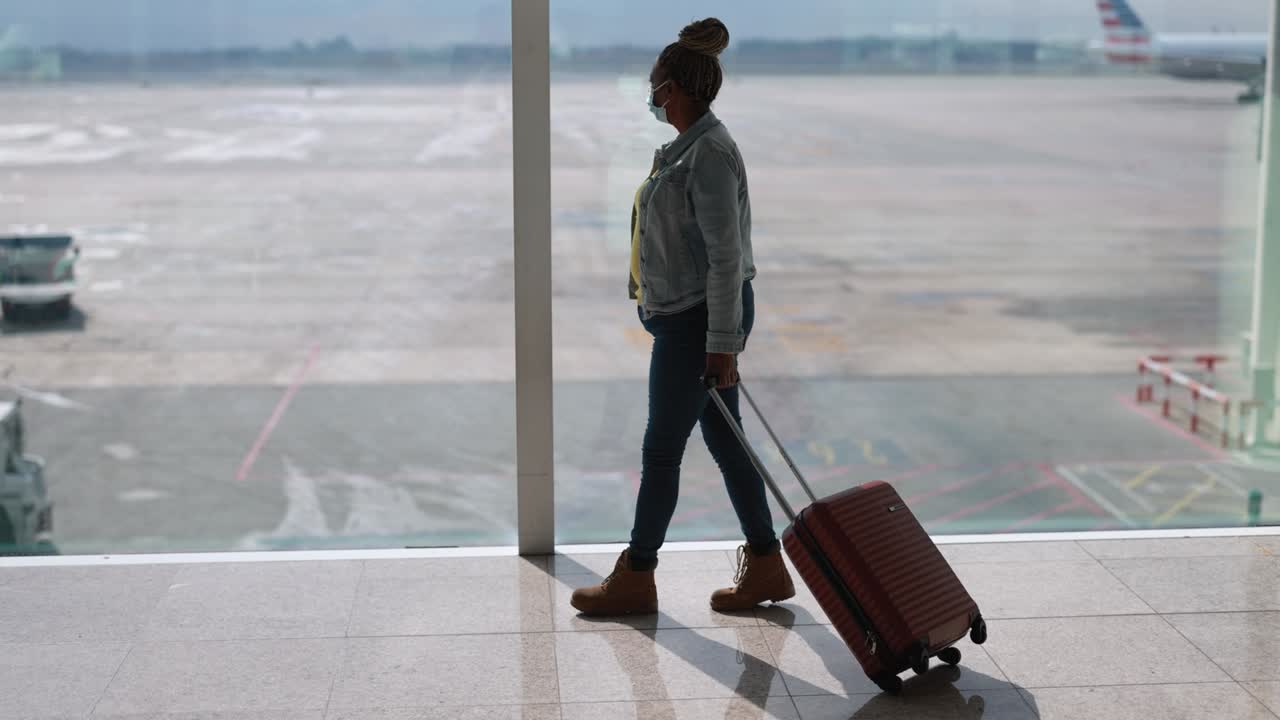 Mature african woman wearing safety face mask inside airport