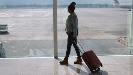 mature african woman wearing safety face mask inside airport