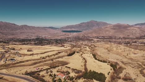 drone ascending to reveal the magnificent tafí del valle, surrounded by mountains with a beautiful lake nestled in the center