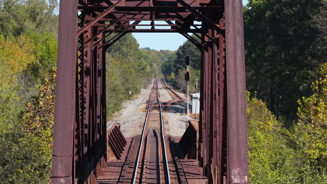 Vista Prospettica di Binari Ferroviari Attraverso un Vecchio Ponte Metallico