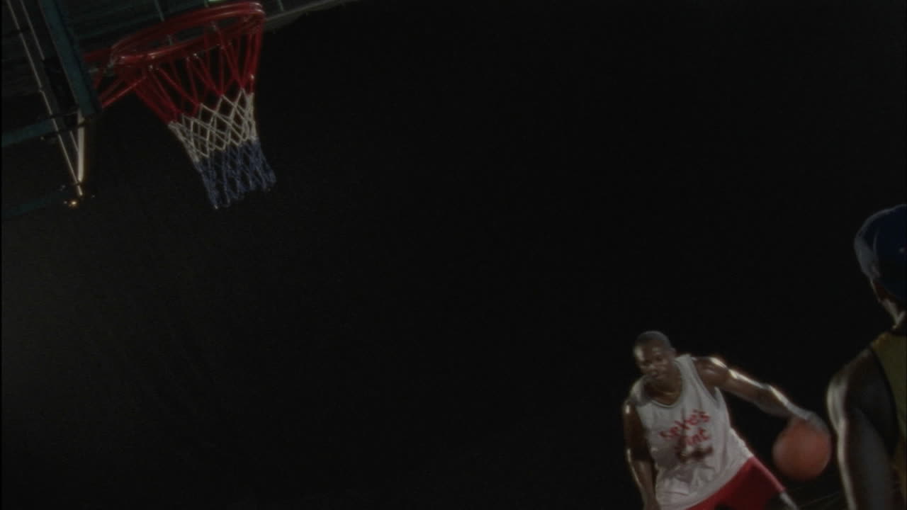 dos hombres juegan baloncesto en una cancha cubierta