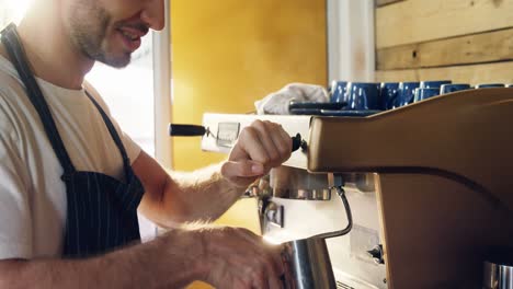 male waiter using coffeemaker machine in cafe 4k