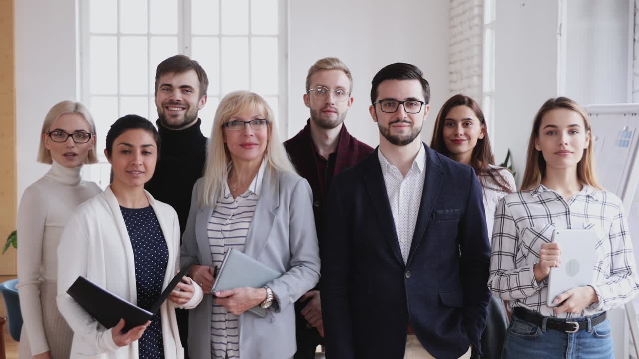 un equipo sonriente de diversas personas de negocios mirando a la cámara.