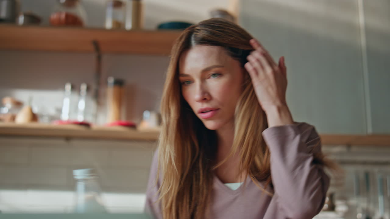 Girl pouring cereal granola preparing breakfast via laptop online recipe closeup