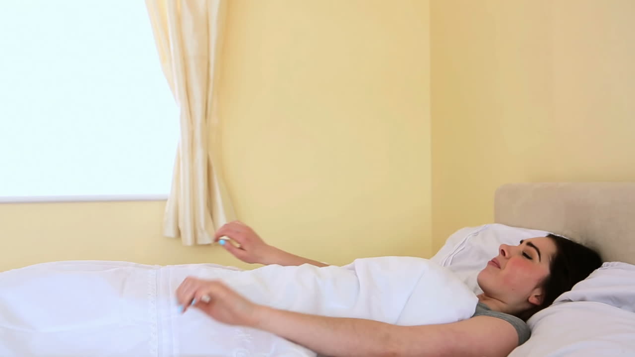 예쁜 여자가 침대에서 깨어납니다.