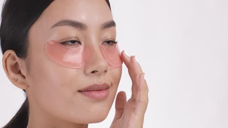 woman applying eye patches for skincare