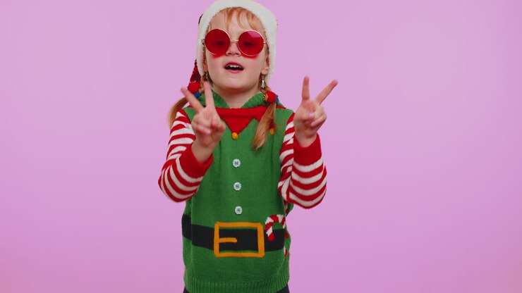 Ragazza elfa di Babbo Natale che ascolta musica con le cuffie, balla in discoteca, scherza e si diverte