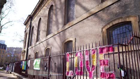 message of love, street art outside a church in london on a sunny day, written in big pink letters