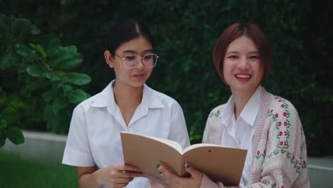 two teen girls studying outdoors