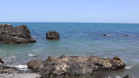 The-rocky-and-rugged-coastline-near-Batumi,-Georgia,-where-waves-splash-against-the-rocks-during-the-daytime,-exemplifies-the-raw-beauty-and-dynamic-coastal-environment