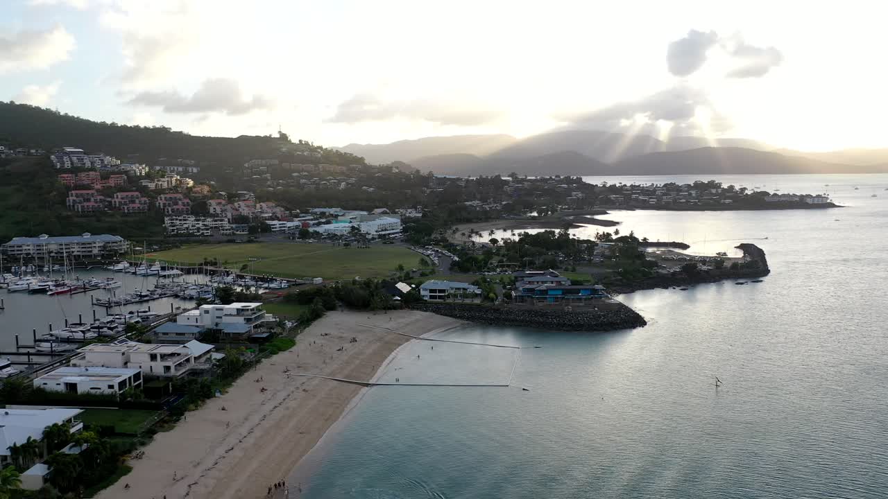 Aerial drone shot over Airlie Beach, Queensland - beach front setting as sun goes down.
