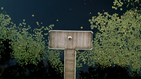 Bride-and-groom-slow-dancing-on-a-dock-on-their-wedding-night-surrounded-by-a-pond-filled-with-lily-pads