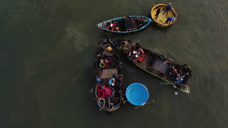 fisherman on traditional fishing boats preparing swim out to sea aerial top down