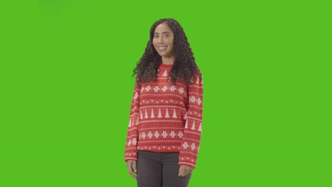 Studio-Portrait-Of-Woman-Wearing-Christmas-Jumper-Against-Green-Screen-Smiling-At-Camera-Saying-Merry-Christmas