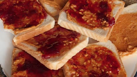 plato lleno de mantequilla de maní y sándwiches de jalea girando, girando alrededor