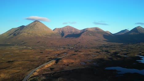 Flug-über-Eine-Hochlandstraße-Mit-Roten-Cuillin-Bergen,-Die-Im-Sonnenaufgang-In-Sligachan-Auf-Der-Insel-Skye-In-Schottland-Leuchten