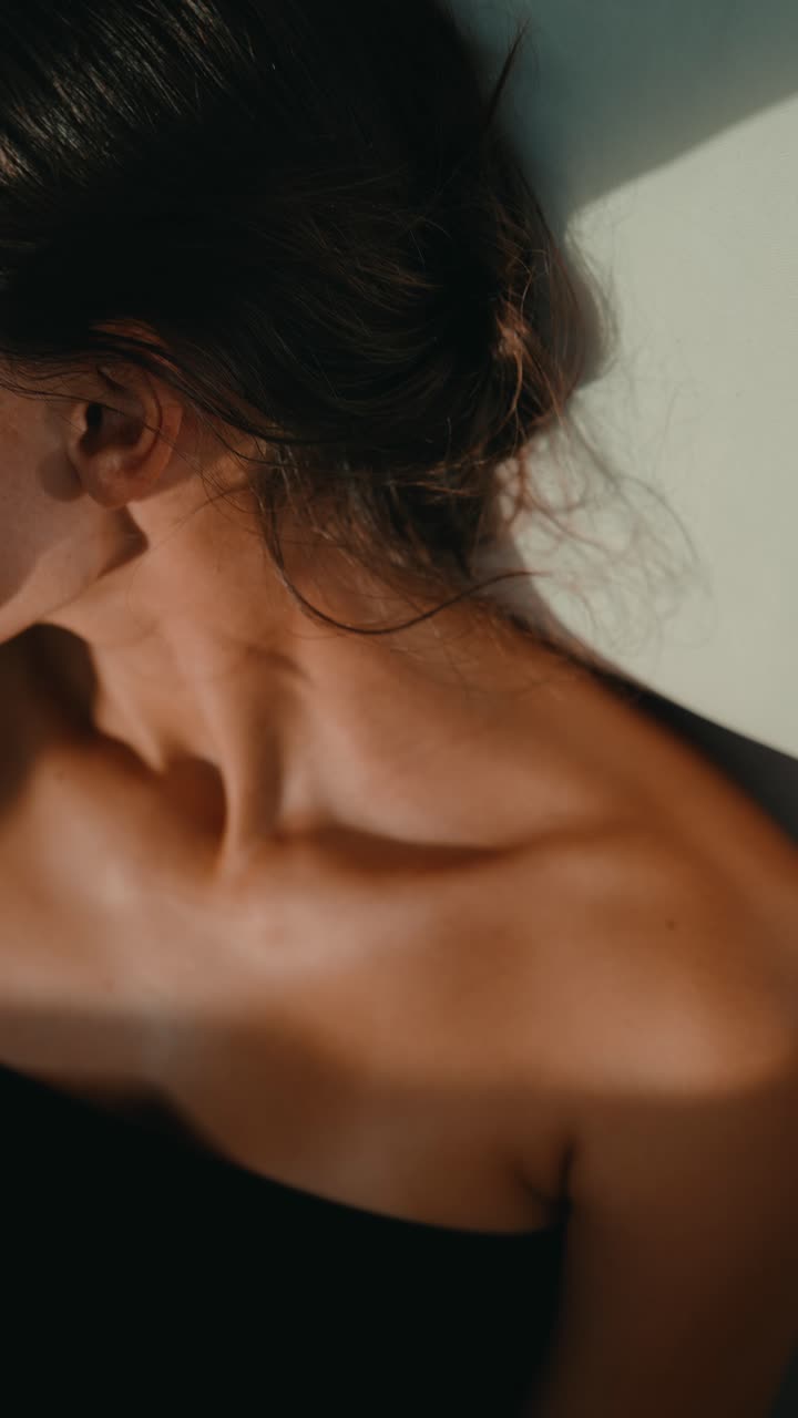 Ritratto ravvicinato di una donna serena con luce naturale e ombre