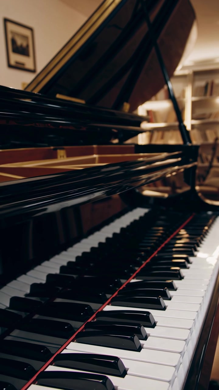 Close-up of Grand Piano Keys in an Elegant Room with Bookshelves