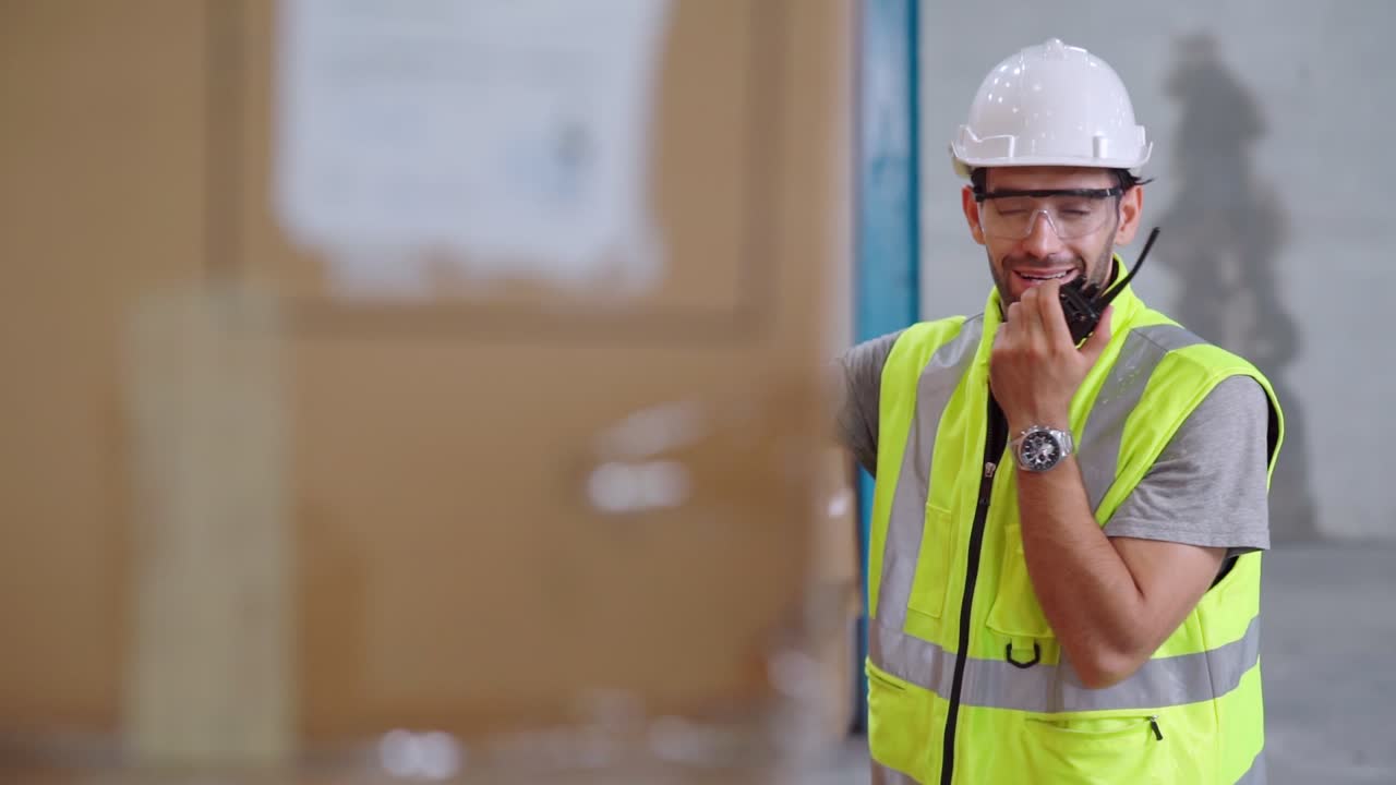 Professional cargo worker talks on portable radio to contact another worker
