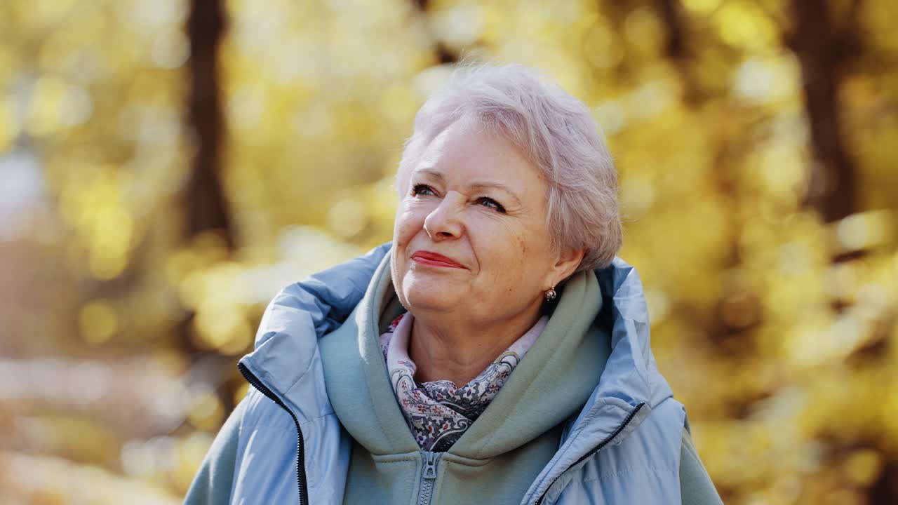 Portrait of a Smiling Senior Woman in an Autumn Park