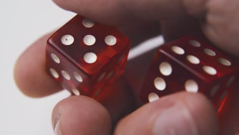 young man throws dices with white spots to light surface