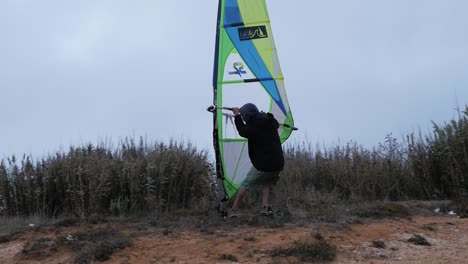 slow motion of portuguese windsurfer trying out his sail on a skate and going super fast!