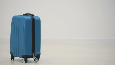 cropped slowmotion of happy young man ready for the trip with his suitcase packed over white background.