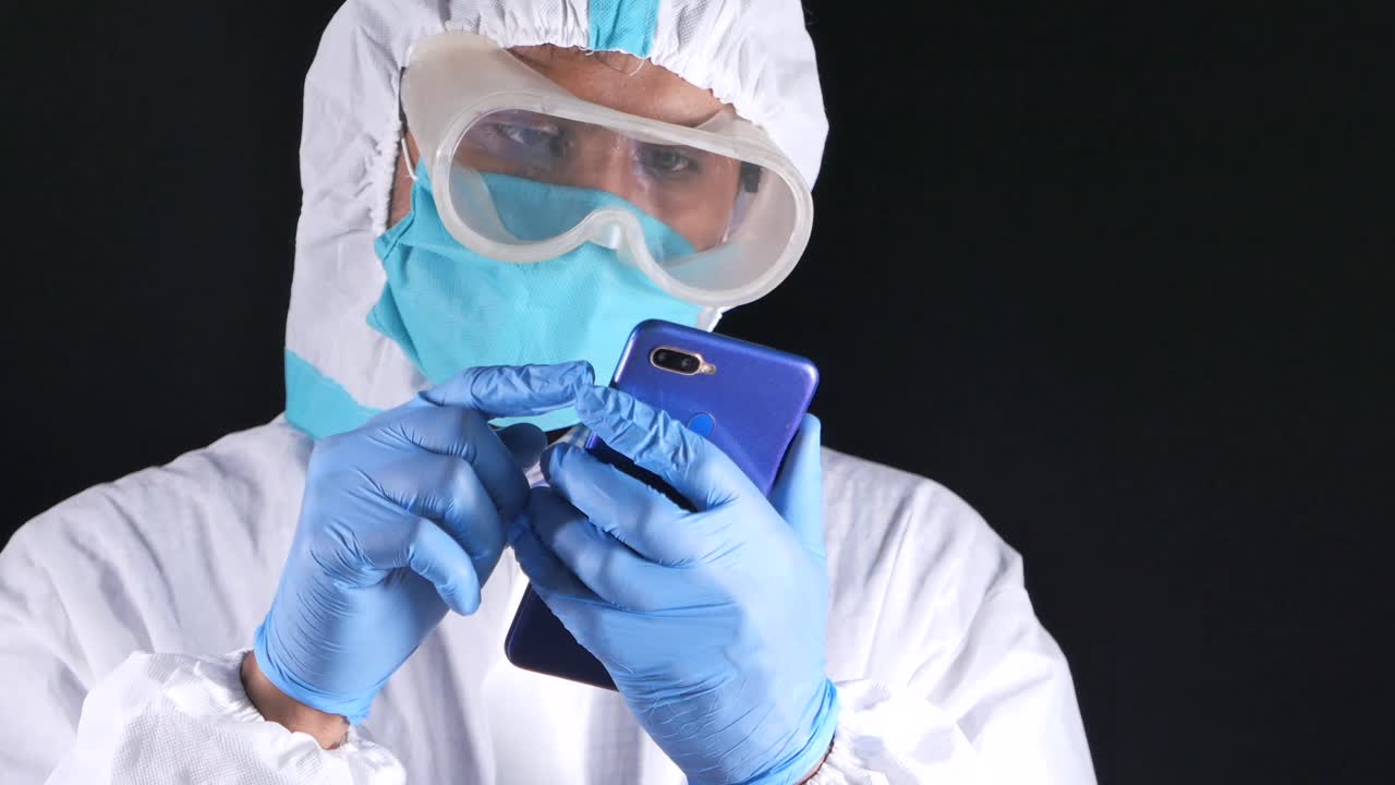 trabajador sanitario que utiliza un teléfono inteligente con equipo de protección