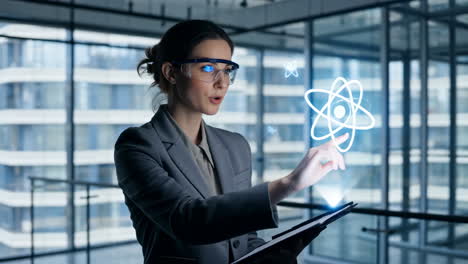 woman interacting with holographic atom in augmented reality office