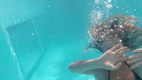 mujer nadando bajo el agua en una bonita piscina